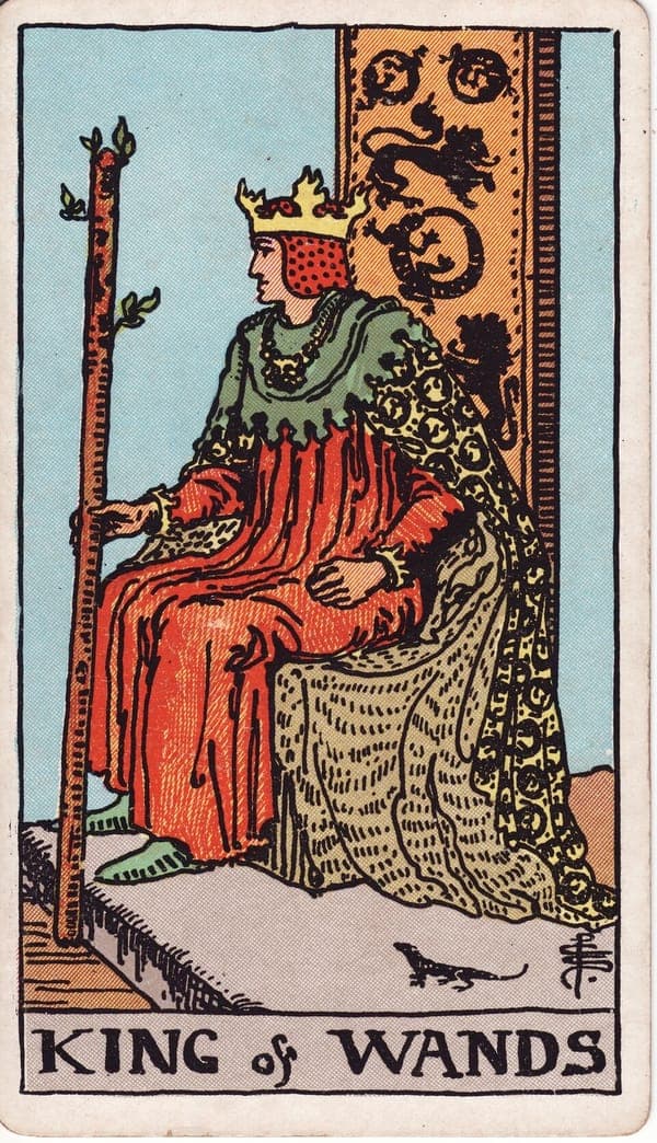 King of Wands tarot card: A king sits forward on his throne as if about to stand — fire never fully at rest — holding a living, sprouting wand.