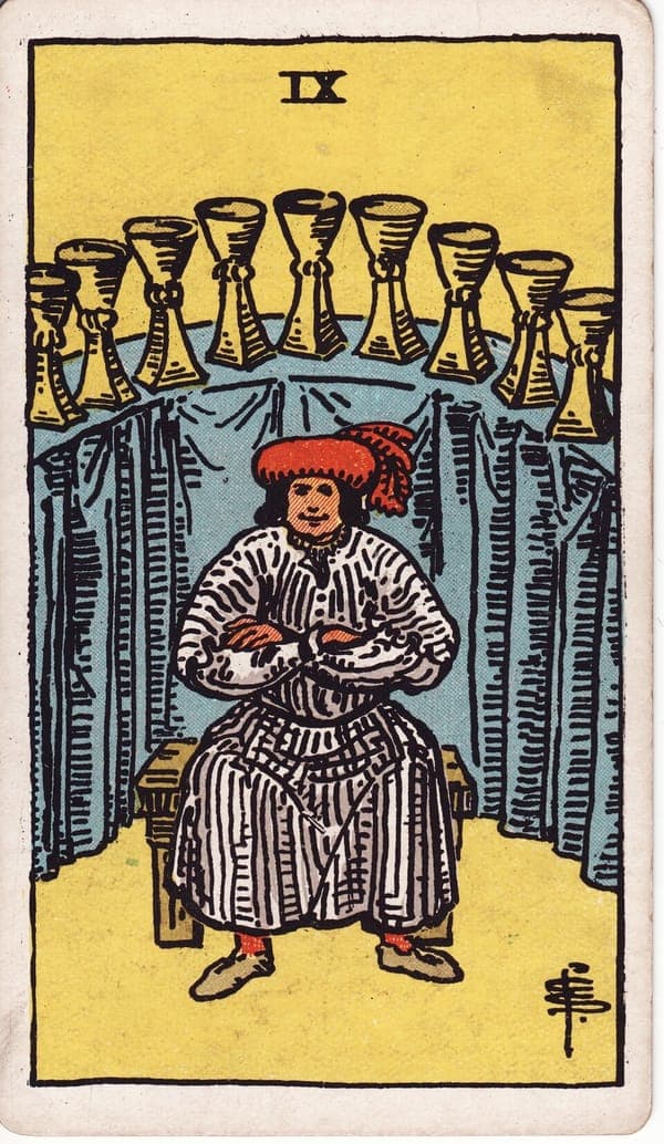 Nine of Cups tarot card: A well-fed host sits on a plain bench, arms folded, contentment worn like a garment.