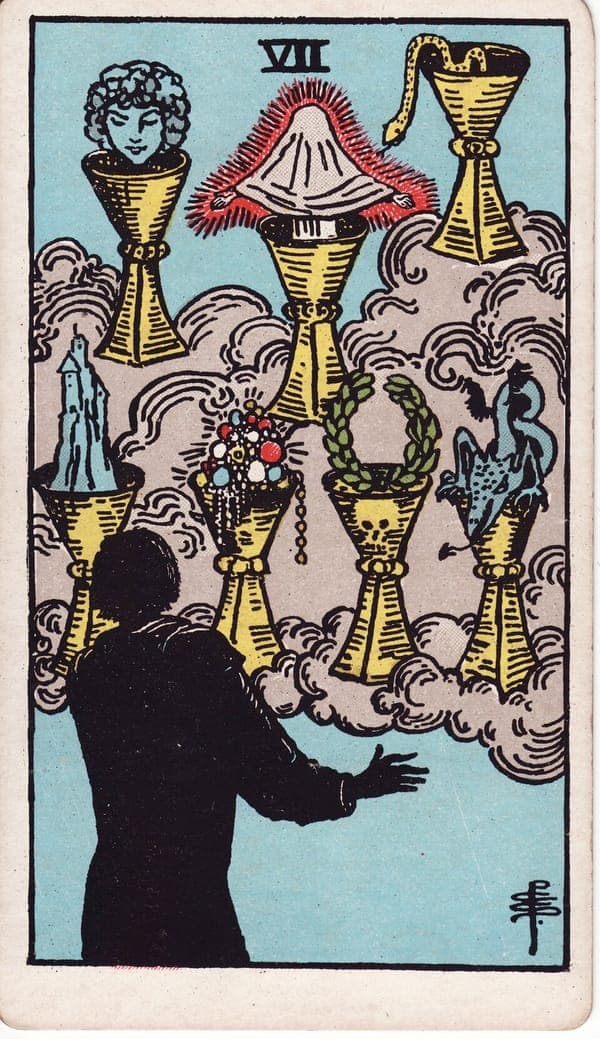 Seven of Cups tarot card: A silhouetted figure faces seven cups arrayed on cloud, each spilling a vision: a woman's face, a shrouded figure aglow, a snake, a castle, jewels, a laurel wreath shadowed by a skull on the cup, a dragon.