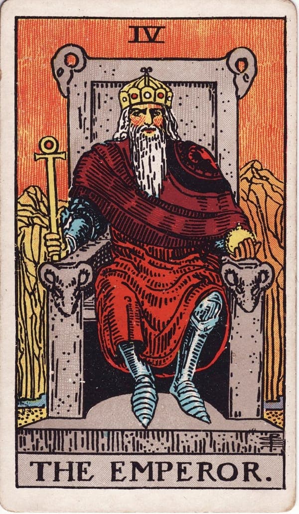 The Emperor tarot card — A stern crowned figure sits on a massive stone throne carved with rams' heads — the sign of Aries. H
