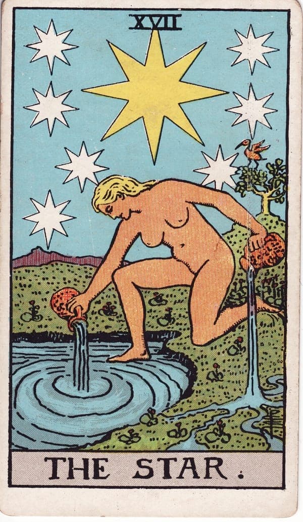The Star tarot card — A naked woman kneels at a pool beneath a great eight-pointed star ringed by seven smaller ones, pour