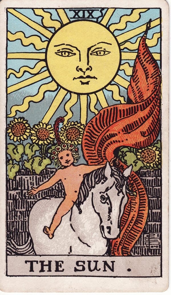 The Sun tarot card — A radiant sun with a calm human face fills the sky above a garden wall crowned with sunflowers. A na